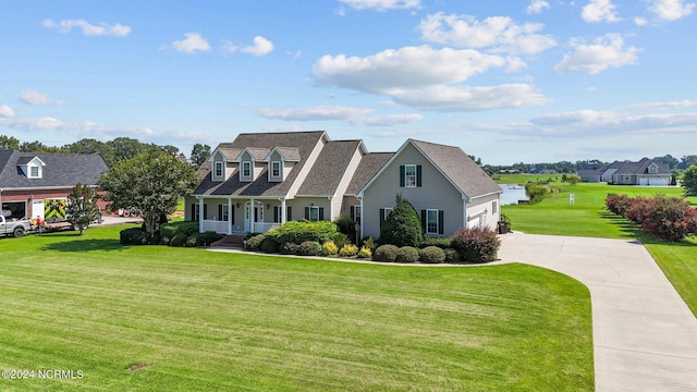 cape cod home featuring a garage, driveway, a front lawn, and covered porch