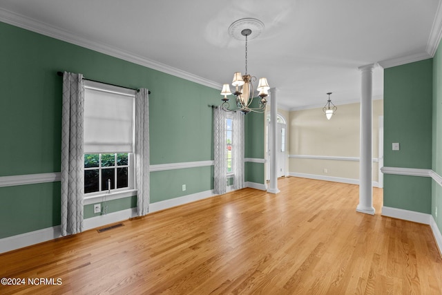 unfurnished dining area with crown molding, visible vents, decorative columns, and wood finished floors