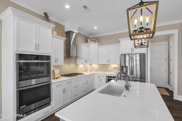 kitchen featuring pendant lighting, white cabinets, wall chimney exhaust hood, and appliances with stainless steel finishes