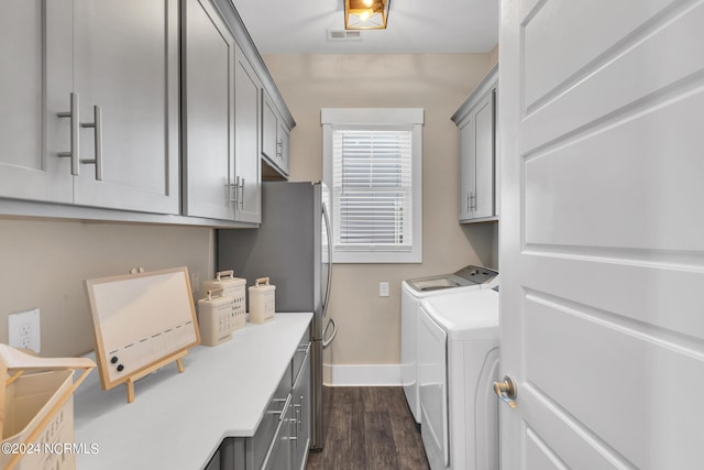 laundry area featuring cabinets, dark wood-type flooring, and independent washer and dryer