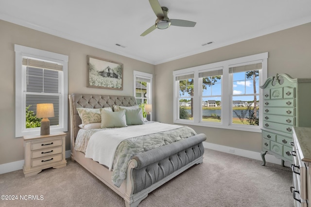 carpeted bedroom with ornamental molding, a water view, and ceiling fan