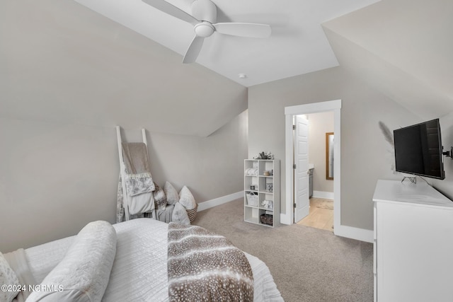 bedroom with lofted ceiling, connected bathroom, light colored carpet, and ceiling fan