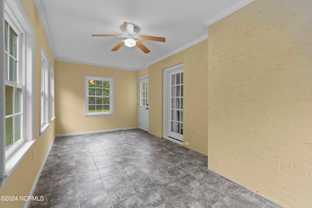 spare room featuring crown molding, brick wall, and ceiling fan