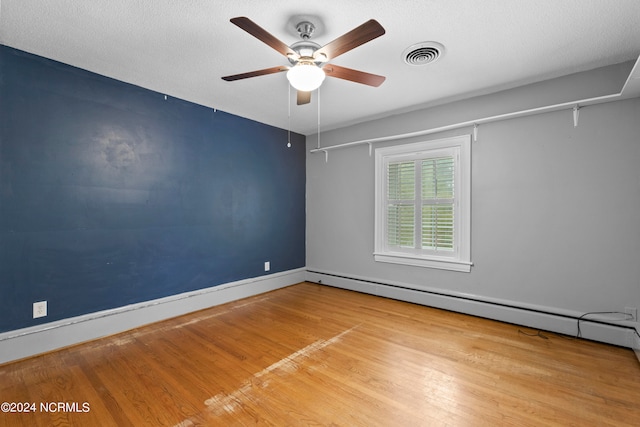 empty room with wood-type flooring, a textured ceiling, ceiling fan, and baseboard heating