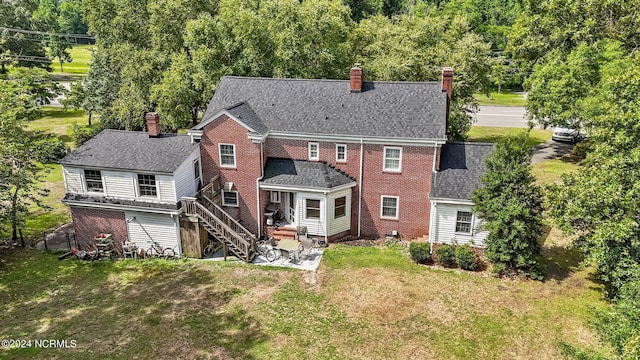 back of house with a patio and a lawn