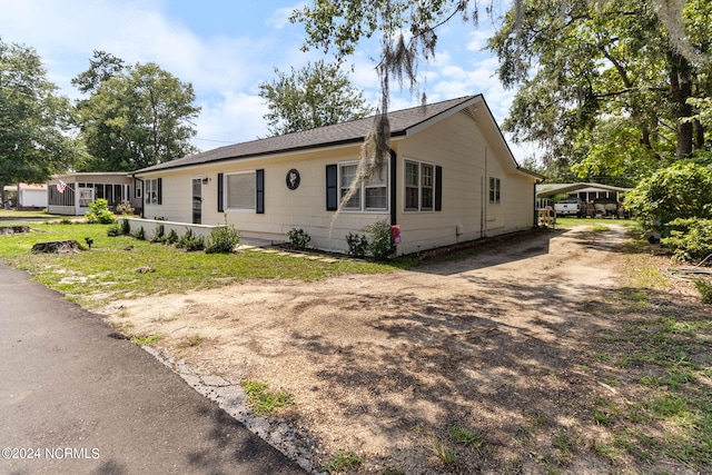 view of home's exterior featuring driveway and a carport