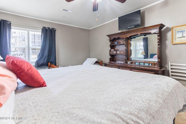 bedroom featuring multiple windows, ceiling fan, and crown molding