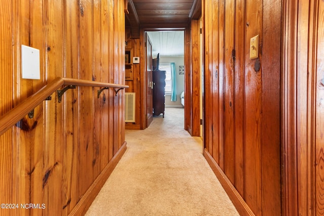 hall with wood ceiling, light colored carpet, wood walls, and visible vents