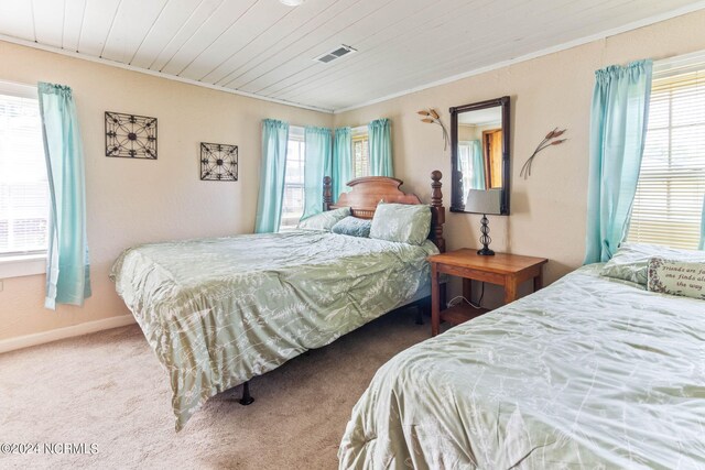 bedroom featuring multiple windows, ornamental molding, and carpet flooring