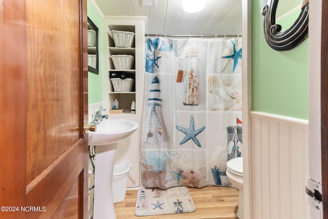 full bath with a wainscoted wall, a shower with shower curtain, wood finished floors, and toilet