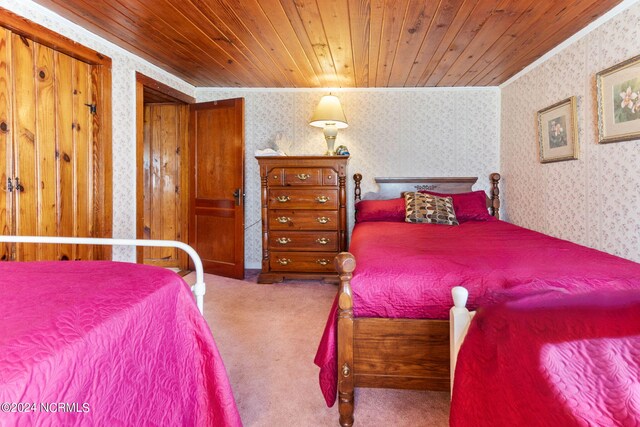 carpeted bedroom featuring wooden ceiling and crown molding