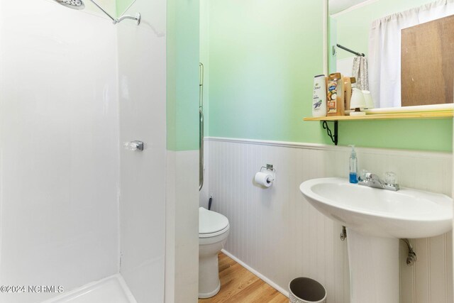 bathroom featuring hardwood / wood-style flooring, a shower, and toilet