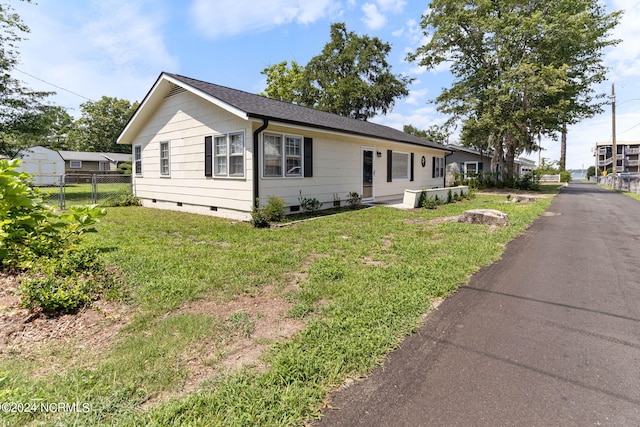 view of front of home with a front lawn, crawl space, and fence