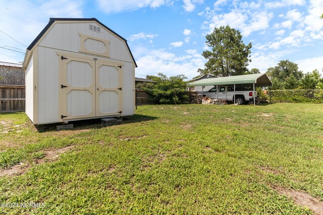 view of outbuilding with a carport and a lawn