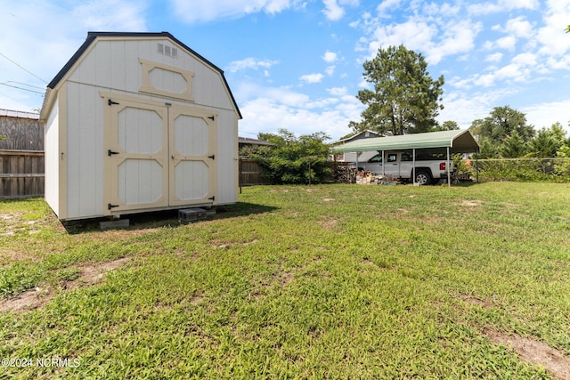 view of shed with a carport and fence