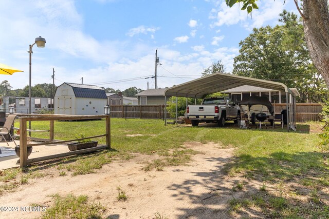 view of yard with a carport and a storage shed