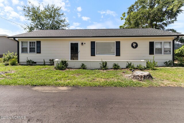 single story home with a shingled roof and a front yard