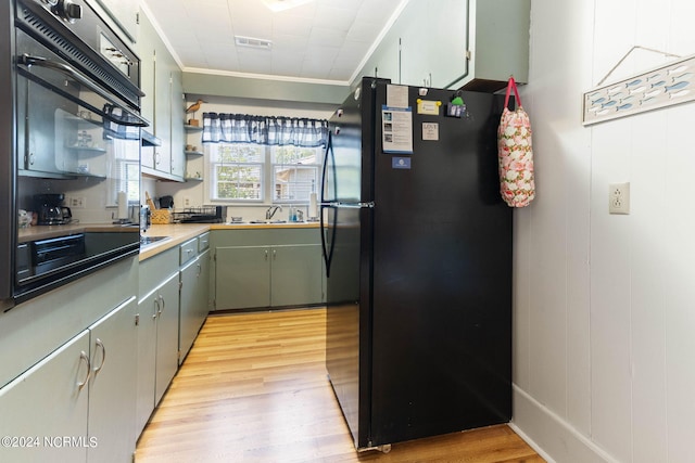 kitchen featuring light wood-style floors, freestanding refrigerator, visible vents, and crown molding