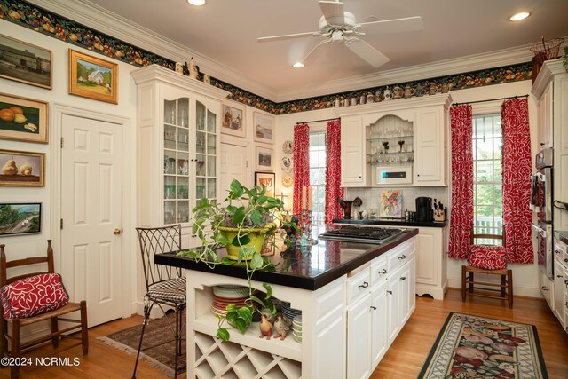 kitchen with white cabinetry, light hardwood / wood-style floors, stainless steel gas cooktop, and ceiling fan