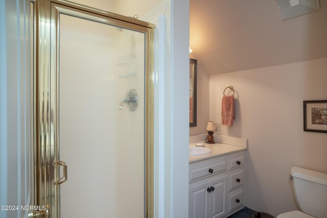 bathroom featuring a shower with door, toilet, and vanity