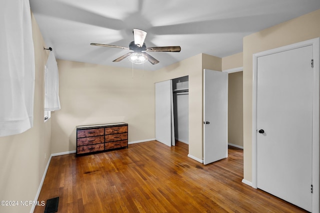 unfurnished bedroom featuring a ceiling fan, baseboards, visible vents, and hardwood / wood-style floors