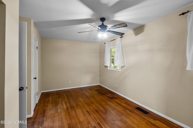 spare room featuring ceiling fan, wood finished floors, visible vents, and baseboards