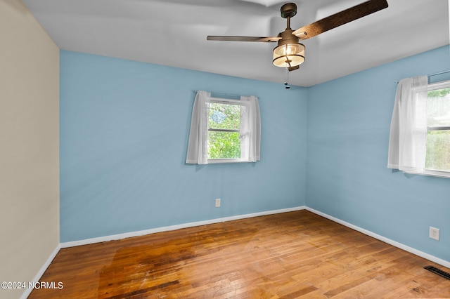 unfurnished room with visible vents, ceiling fan, baseboards, and wood finished floors