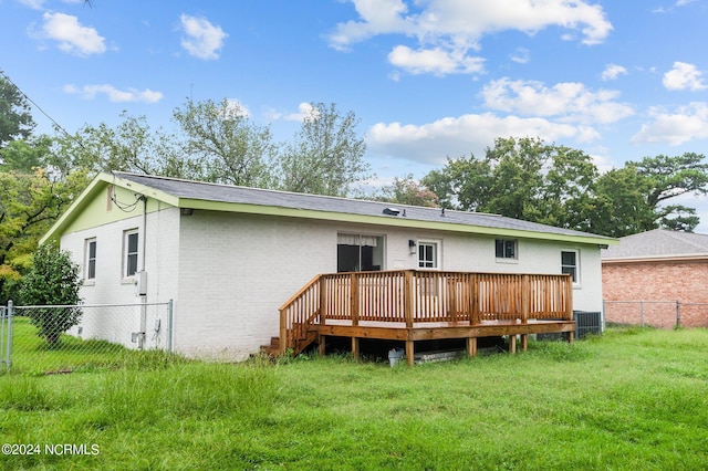 rear view of house featuring a yard, fence, a deck, and brick siding