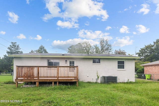 back of house featuring central air condition unit, fence, a lawn, and a wooden deck