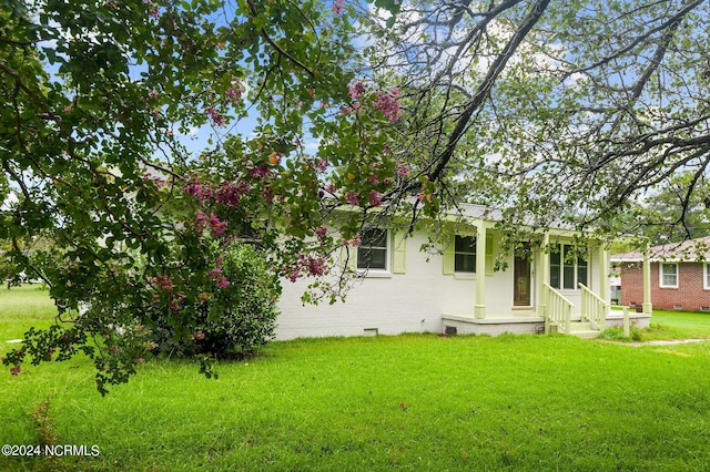 view of front of property featuring brick siding, crawl space, and a front yard