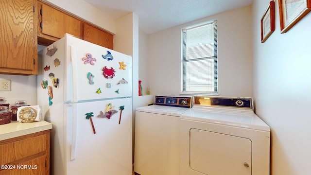 laundry area with washer and dryer and cabinets