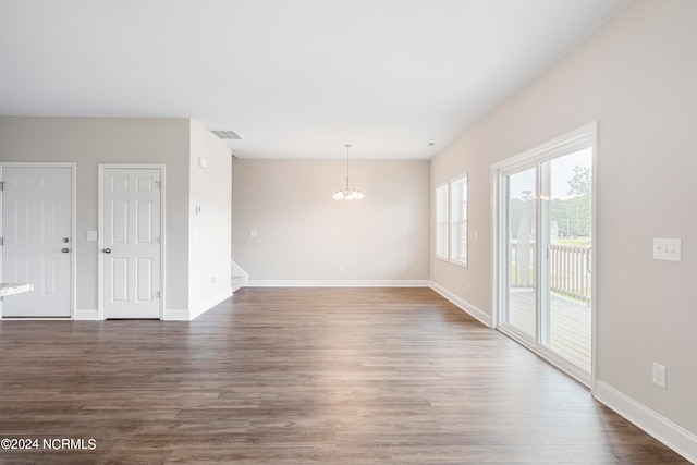 unfurnished room featuring an inviting chandelier and wood-type flooring