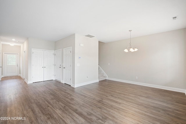 empty room featuring a notable chandelier and hardwood / wood-style floors