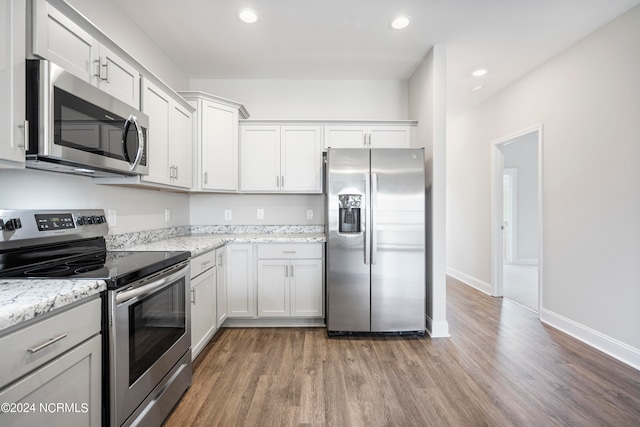 kitchen featuring white cabinetry, light wood-type flooring, light stone counters, and stainless steel appliances