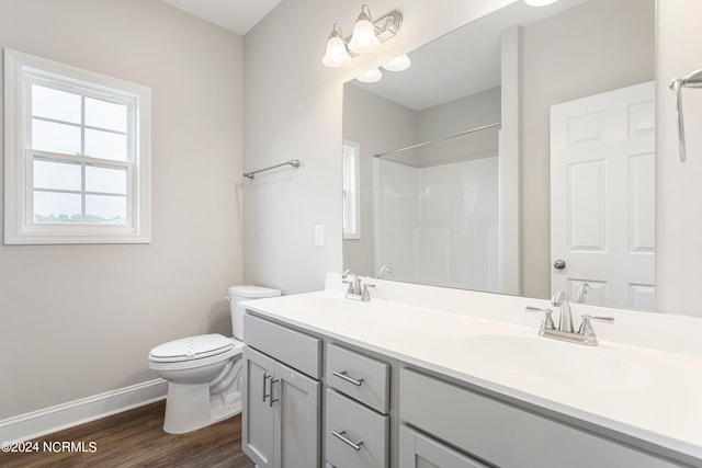 bathroom with hardwood / wood-style flooring, toilet, and double sink vanity