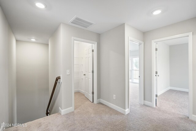 hall featuring light colored carpet