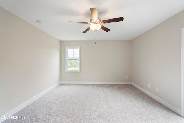 empty room featuring ceiling fan and light colored carpet