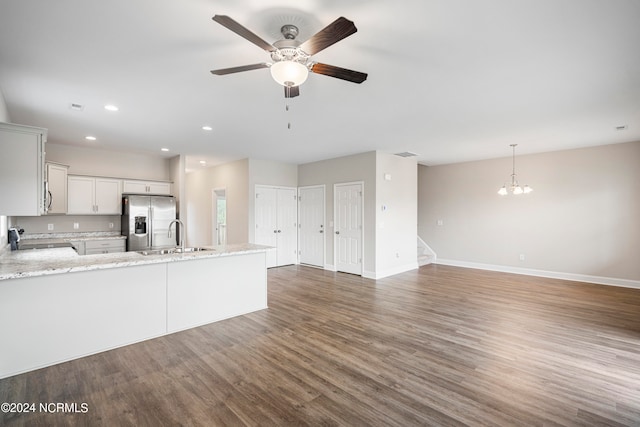 kitchen with stove, sink, ceiling fan with notable chandelier, stainless steel refrigerator with ice dispenser, and wood-type flooring