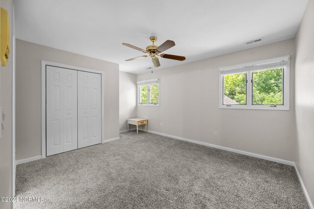 unfurnished bedroom featuring carpet, a closet, and ceiling fan