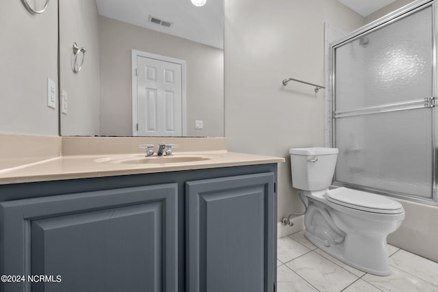 full bathroom with combined bath / shower with glass door, toilet, vanity, and tile patterned flooring