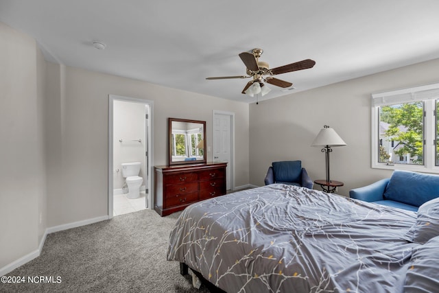 bedroom with ceiling fan, ensuite bath, multiple windows, and carpet