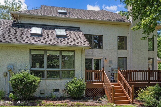 rear view of property featuring a deck