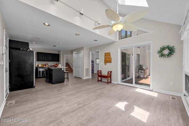 interior space featuring ceiling fan, light hardwood / wood-style flooring, and vaulted ceiling