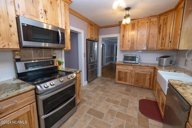 kitchen featuring appliances with stainless steel finishes, sink, backsplash, and decorative light fixtures