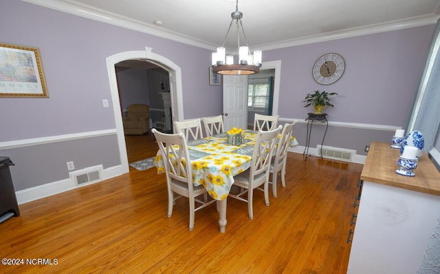 dining space with hardwood / wood-style flooring and crown molding