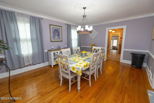 dining area with crown molding and hardwood / wood-style flooring