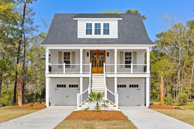3404 Eagle Crest Dr SW, Supply, NC 28462 - raised beach house featuring stairway, a porch, concrete driveway, french doors, and an attached garage
