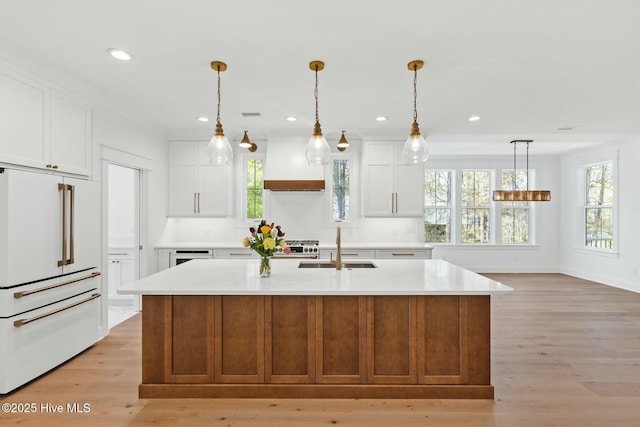 3404 Eagle Crest Dr SW, Supply, NC 28462 - kitchen with high end fridge, light countertops, light wood-style floors, custom exhaust hood, and a sink