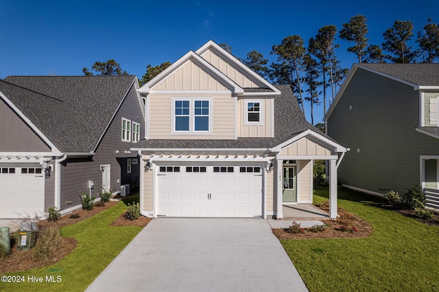 craftsman house featuring cooling unit, a garage, and a front yard