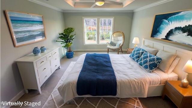 carpeted bedroom featuring a tray ceiling, ceiling fan, and ornamental molding